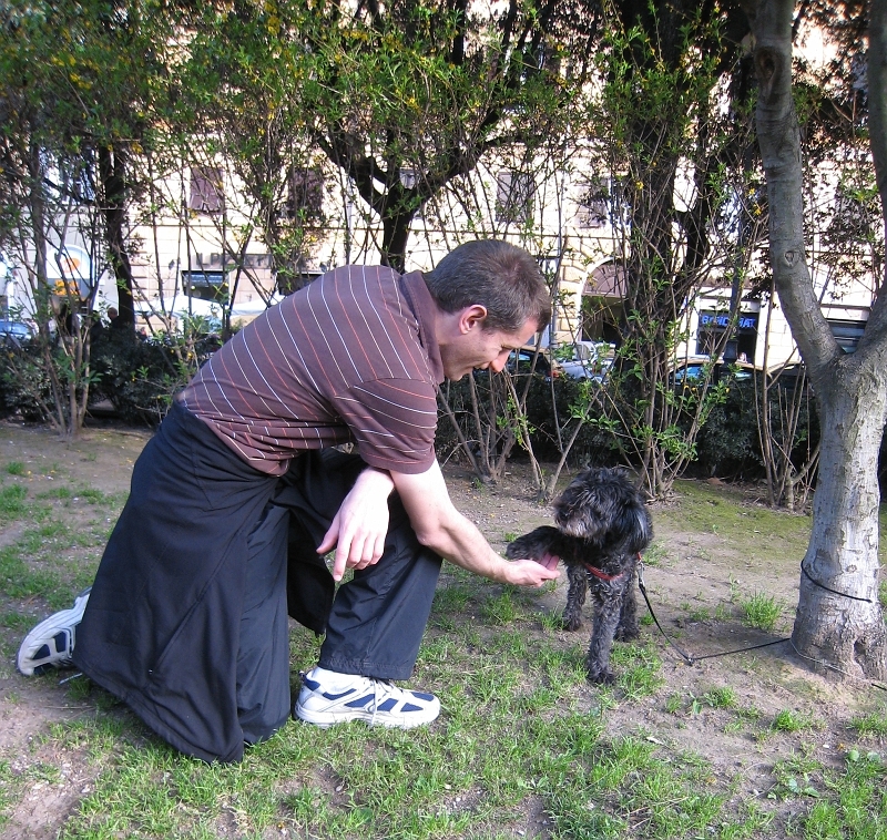 IMG_2303.JPG - Dan shakes hands with Nuvolina, a little dog we met at a park while we were waiting for our pizza place to open (things open late in Italy).  There were dogs everywhere.  You can totally bring your dog wherever you want in Italy.